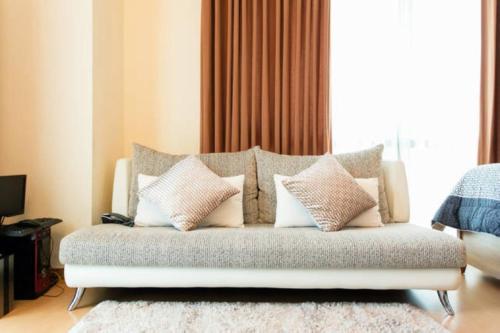 a couch with pillows on it in a living room at Avant Apartments at The Fort in Manila
