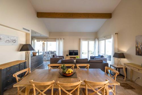 a living room with a wooden table and chairs at Domaine de la Durantie - Villas avec Spa de nage in Castelnau-de-Montmiral