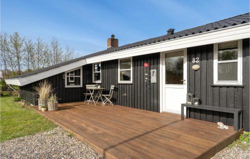 ein schwarzes Tiny House mit Holzterrasse in der Unterkunft Stunning Home In Hemmet With Wifi in Hemmet