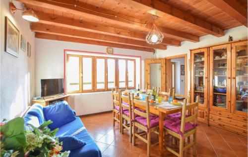 a dining room with a table and a blue couch at Awesome Home In Sovramonte With Wifi in Sovramonte