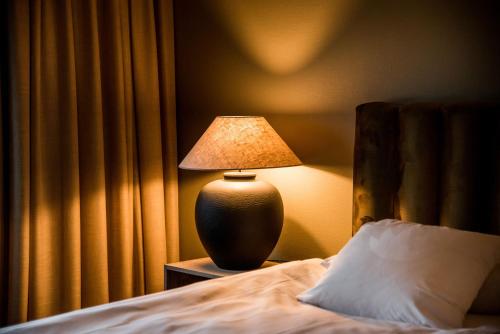 eine Lampe auf einem Nachttisch neben einem Bett in der Unterkunft Billingehus in Skövde