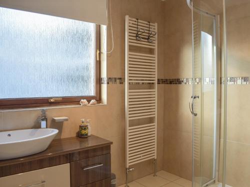 a bathroom with a glass shower and a sink at Mousebank in Forth