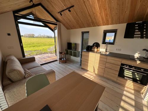 a living room with a couch and a table at Gastenverblijf De Natureluur in Noorden