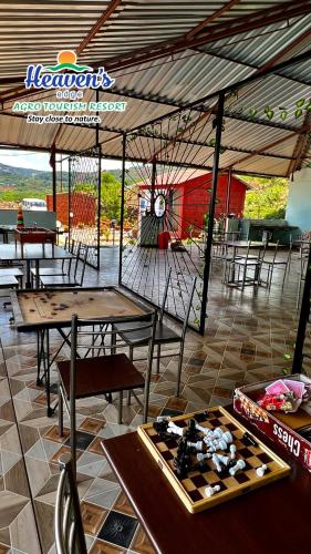 a restaurant with tables and chairs and a clock at Heavens Edge Resort in Mahabaleshwar