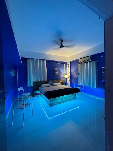 a blue bedroom with a bed and a table and chairs at Casa Felice Jonak in Jorhāt