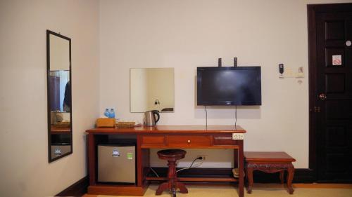 a room with a desk with a television on a wall at Villa KiengKham晶康民宿 in Luang Prabang