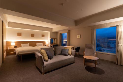 Habitación de hotel con cama y sofá en Authent Hotel Otaru, en Otaru