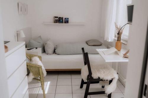 a white living room with a couch and a table at Haus Sandröschen in Norderney