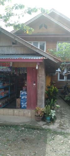 a store with a red door in front of a house at Purabarang Homestay in Rantepao