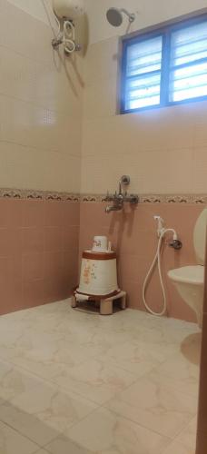 a bathroom with a shower and a cake in it at Coral Shelters Service Apartments Thuvariman in Madurai