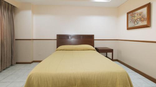 a bedroom with a bed in a room at Garden Plaza Hotel Manila in Manila