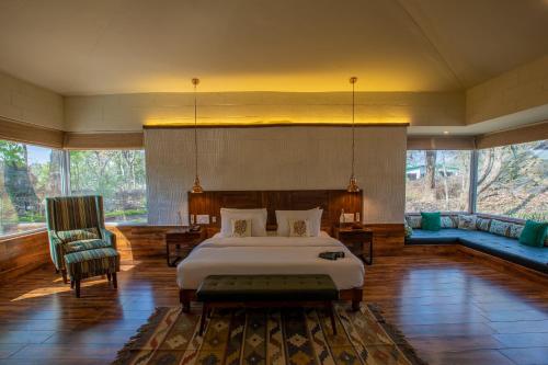 a bedroom with a bed and a couch in a room at The Riverwood Forest Retreat - Kanha in Kānha