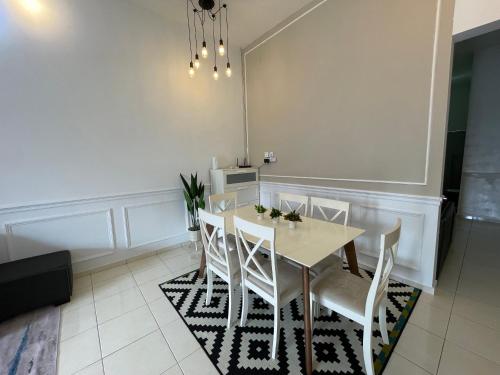 a dining room with a table and white chairs at GS24 Muar in Muar