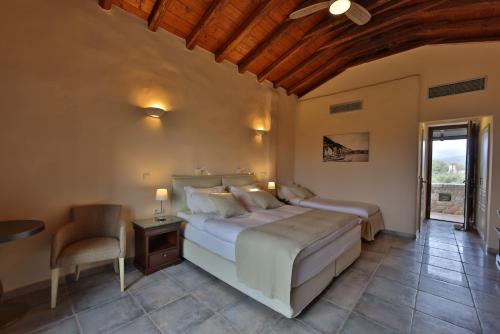 a bedroom with a bed and a table and a chair at Castello Antico Hotel in Gythio