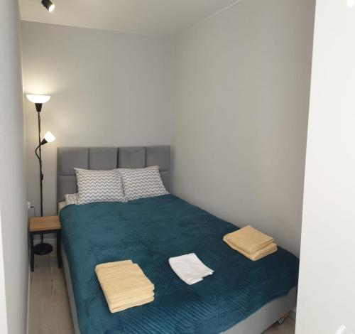 Un dormitorio con una cama azul con toallas. en Apartamenty Katowice Chopina 16, en Katowice