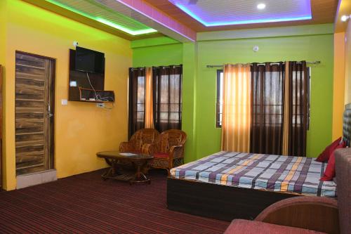 Cette chambre dispose de murs verts, d'un lit et d'une table. dans l'établissement Hotel Mountain View And Rooftop Restaurant, à Pithorāgarh