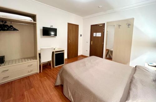 a bedroom with a bed and a desk and a mirror at Le Naiadi Park Hotel Sul Lago in Bolsena