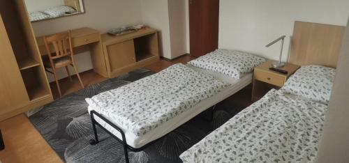 a room with two beds and a table with a lamp at Ubytovanie v súkromí Nová Baňa in Nová Baňa