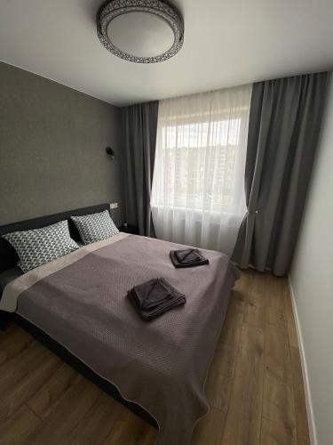 a bedroom with a large bed with a window at ETG Apartment in Mažeikiai