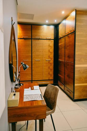 a desk with a lamp and a chair in a room at Tredenham Boutique Hotel in Bloemfontein