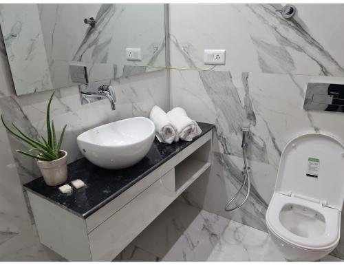 a white bathroom with a sink and a toilet at Hotel Prem Manor, Roorkee in Roorkee