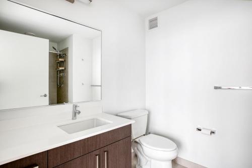 uma casa de banho com um WC, um lavatório e um espelho. em S Loop 1BR w Pool Gym Roof 1 block to L CHI-431 em Chicago
