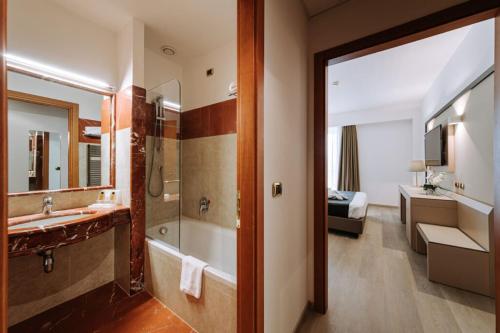 a bathroom with a tub and a sink and a shower at Grand Hotel la Chiusa di Chietri in Alberobello