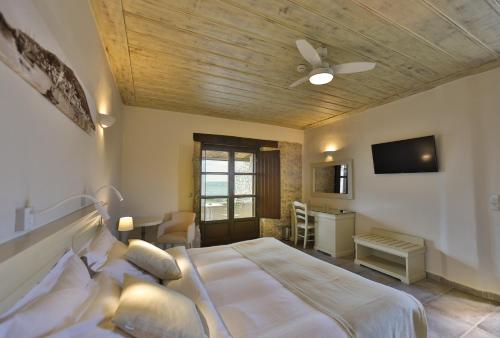a bedroom with a bed and a ceiling fan at Castello Antico Hotel in Gythio