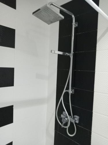 y baño con ducha y pared en blanco y negro. en Nour plage, en Sousse