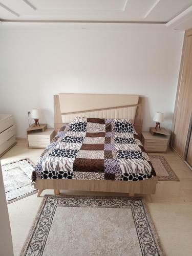 1 dormitorio con 1 cama y 2 mesitas de noche en Nour plage, en Sousse