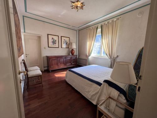 een slaapkamer met een bed, een stoel en een raam bij 030 Trilocale, Pinzolo in Pinzolo
