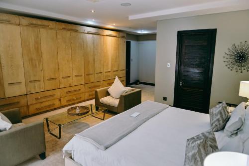 a bedroom with a large bed and a chair at Tredenham Boutique Hotel in Bloemfontein