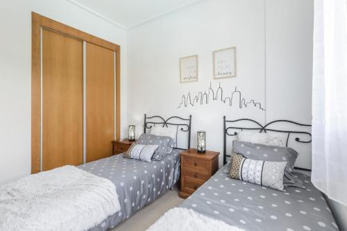 um quarto com 2 camas e um armário de madeira em Casadeluxe Villa La Torre Lenguado em Torre-Pacheco