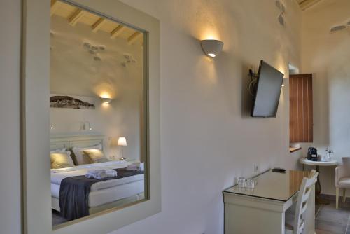 a bedroom with a bed and a mirror in a room at Castello Antico Hotel in Gythio