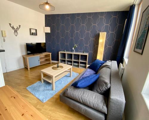 uma sala de estar com um sofá e uma mesa em La Vague Dorée - Hyper-Centre - 15 min de Rouen em Barentin