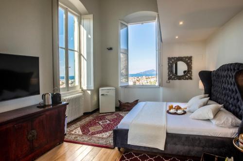 a bedroom with a bed and a tv and windows at Torre Scribanti in Sestri Levante