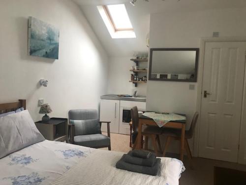 a bedroom with a bed and a table and a kitchen at The Old Police House in Cheddar