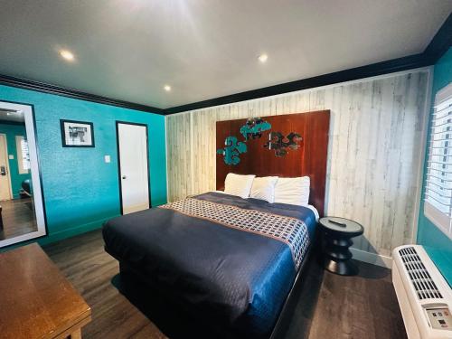 a bedroom with a bed with blue walls at Casa Blanca Inn - Whittier, Los Angeles in Whittier