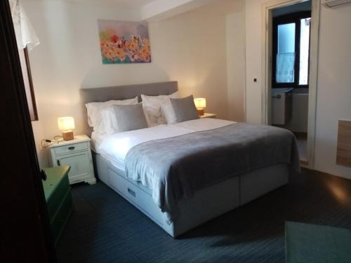 ein Schlafzimmer mit einem großen weißen Bett mit zwei Lampen in der Unterkunft Rooms Serafin in Motovun