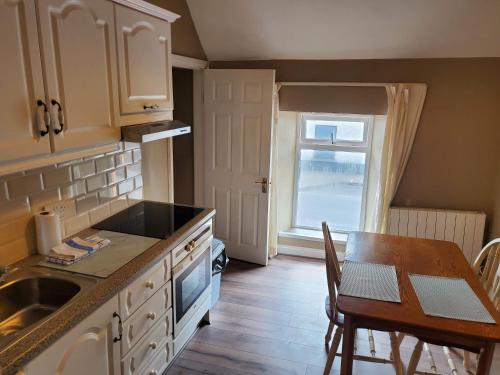 a kitchen with a table and a sink and a window at Apt. 2 - Town Centre Apartment in Bagenalstown