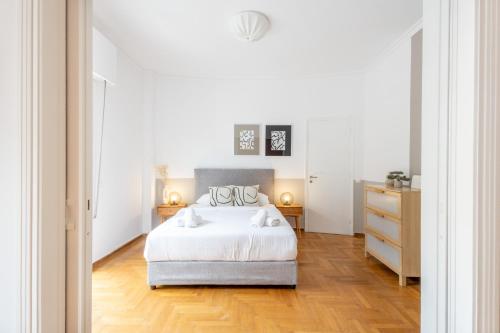 a bedroom with a white bed and a wooden floor at Impressive Minimal 2 bdrm next to Acropolis Museum in Athens
