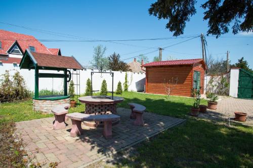 a backyard with a picnic table and a gazebo at Piros Ponty Panzió in Poroszló