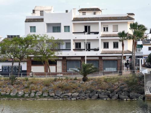 un edificio blanco junto a un cuerpo de agua en Hospederia Doña Lola Zahara en Zahara de los Atunes