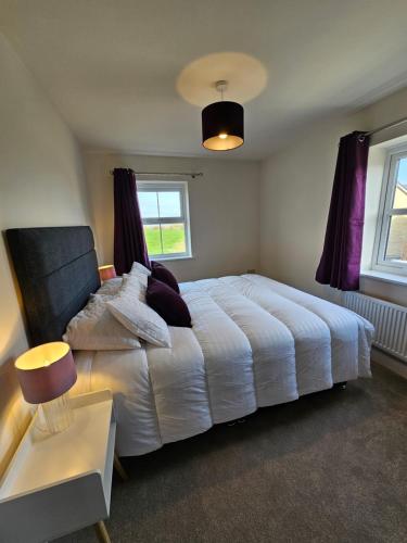 ein Schlafzimmer mit einem weißen Bett und einem Fenster in der Unterkunft The Neal's 4 Bedroom House in Buxton Sleeps 8 in Buxton