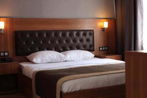 a bedroom with a large bed with a black headboard at Divine Beach Resort Kumburgaz in Buyukcekmece