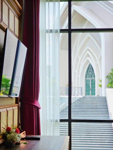 a room with a large window and a staircase at Grand Lord Hotel & Residence - Khao chi chan Pattaya in Na Jomtien