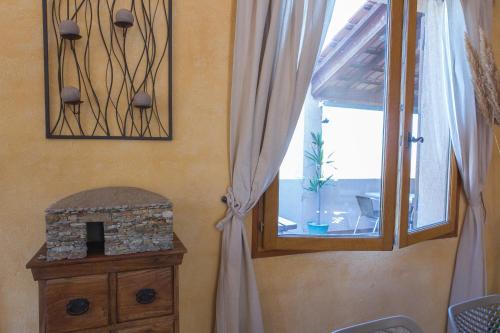 a room with a window and a dresser and a window with a fireplace at Relais de Saleccia in Casta