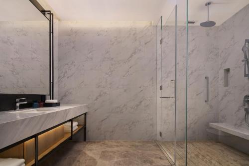 a bathroom with a glass shower and a sink at Courtyard by Marriott Foshan in Foshan