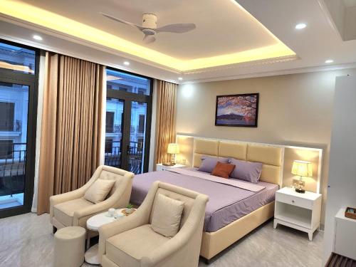 um quarto com uma cama e 2 cadeiras em Sakura Homestay Cao cấp T4 em Gia Lâm Pho