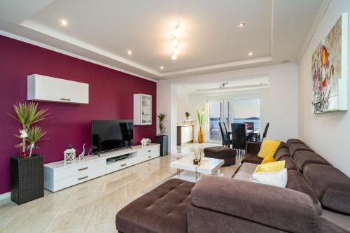 a living room with a couch and a tv at Apartments Sandito in Mlini